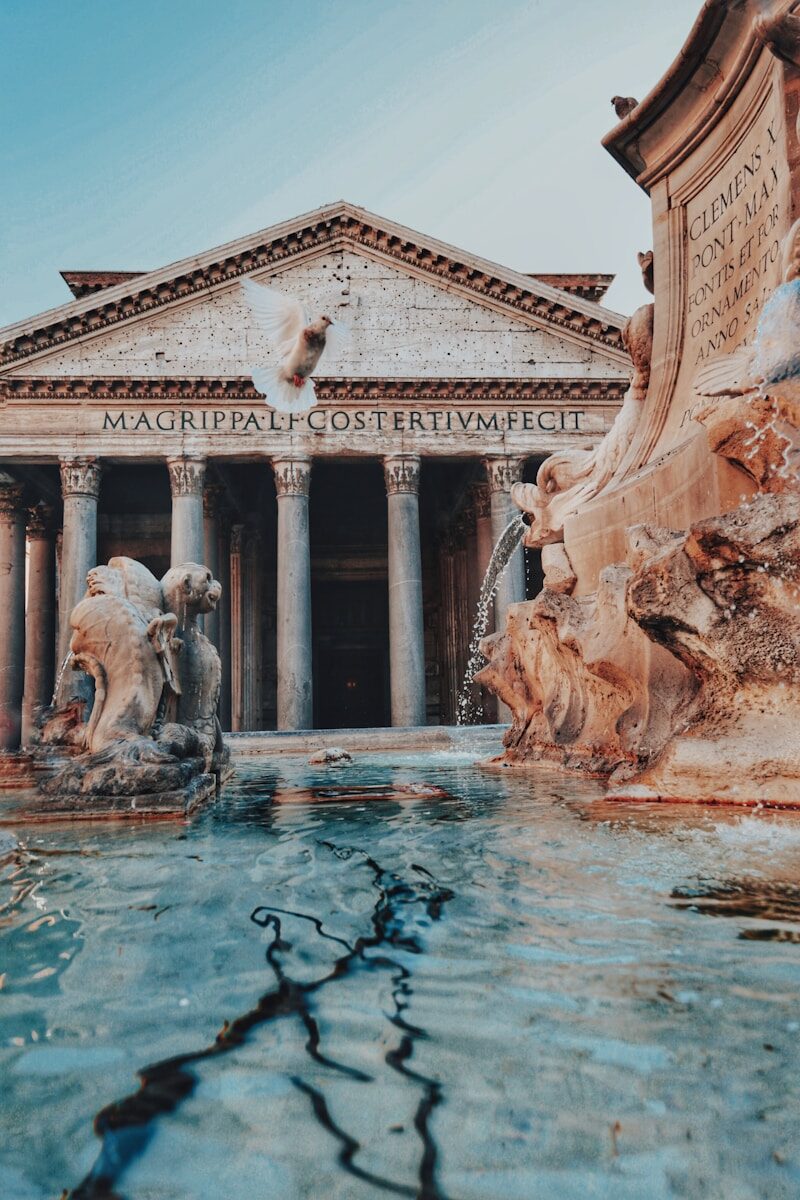 Woman looking up at the exterior facade and fountain of the ancient Pantheon in Piazza della Rotonda, Rome, Italy.
